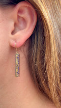 Load image into Gallery viewer, Model wearing Ali&#39;i Old English Dangle Earrings in 14K Yellow Gold
